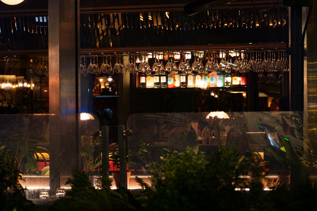 Warmly lit London bar with hanging glasses and bottles