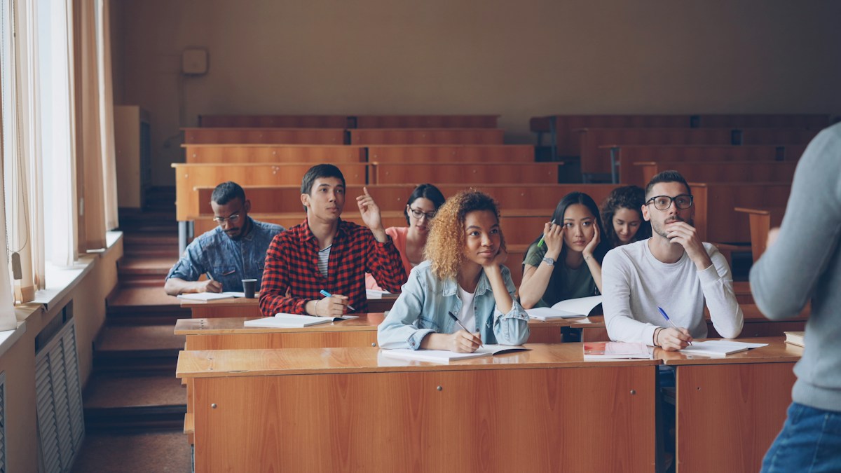 University students listening and taking notes in a lecture hall