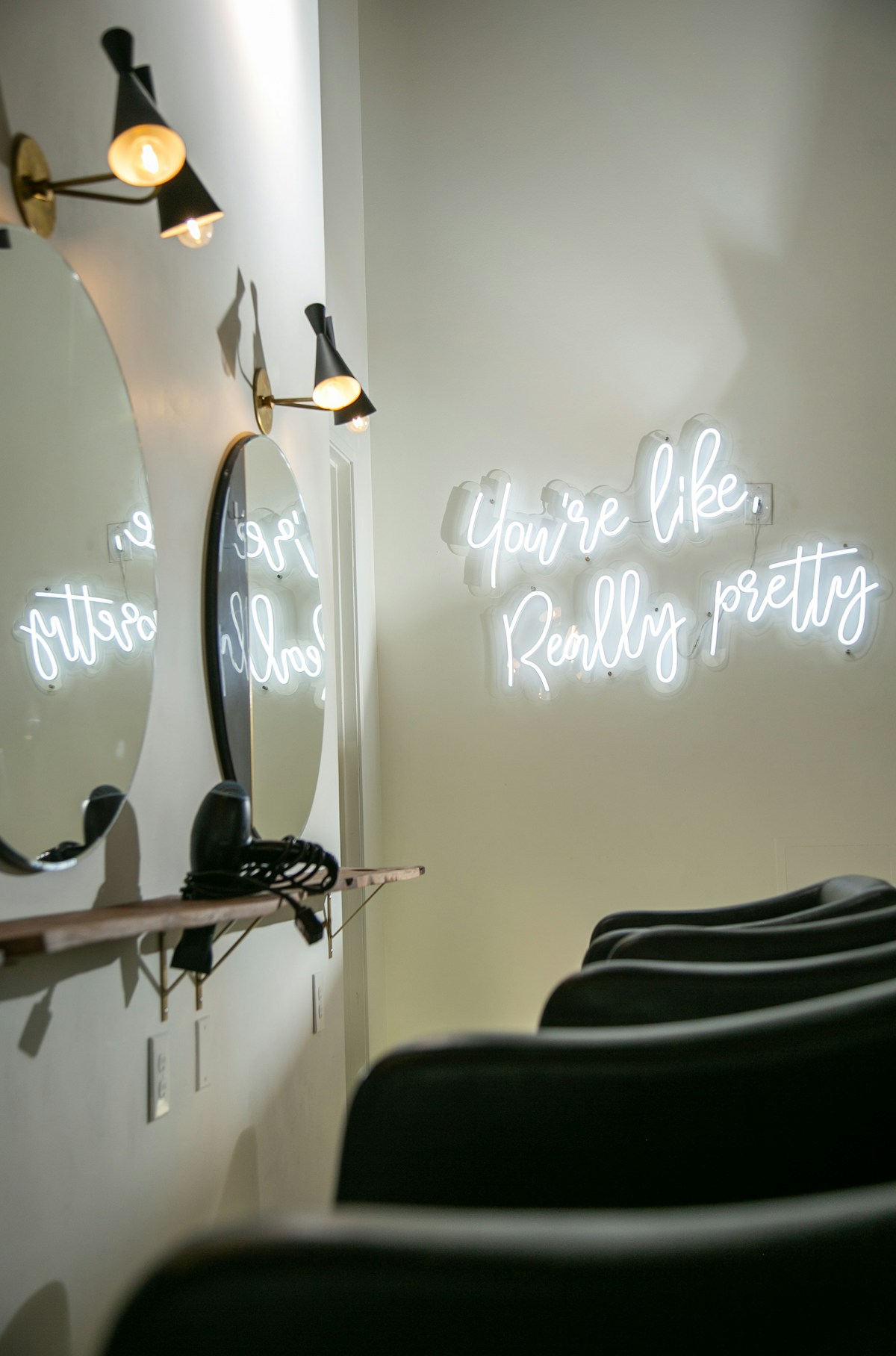 Salon styling chairs beside mirrors and wall lights